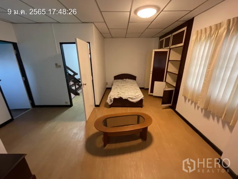 บ้าน ให้เช่าในKhlong Toei, Bangkok - ห้องนอนพร้อมเตียง โต๊ะกลาง และหน้าต่างบานใหญ่ติดผ้าม่าน