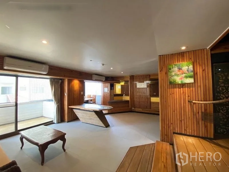 Condominium for rent or sale in Suan Luang, Bangkok - Large living space with multiple air conditioners, balcony access and a centerpiece table.