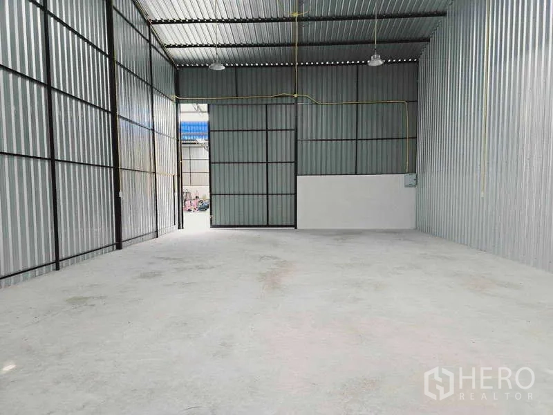 คลังสินค้า ให้เช่าในKhlong Toei, Bangkok - โถงโกดังเปิดโล่ง มองไปยังประตูสไลด์ขนาดใหญ่และผนังบริการด้านข้าง