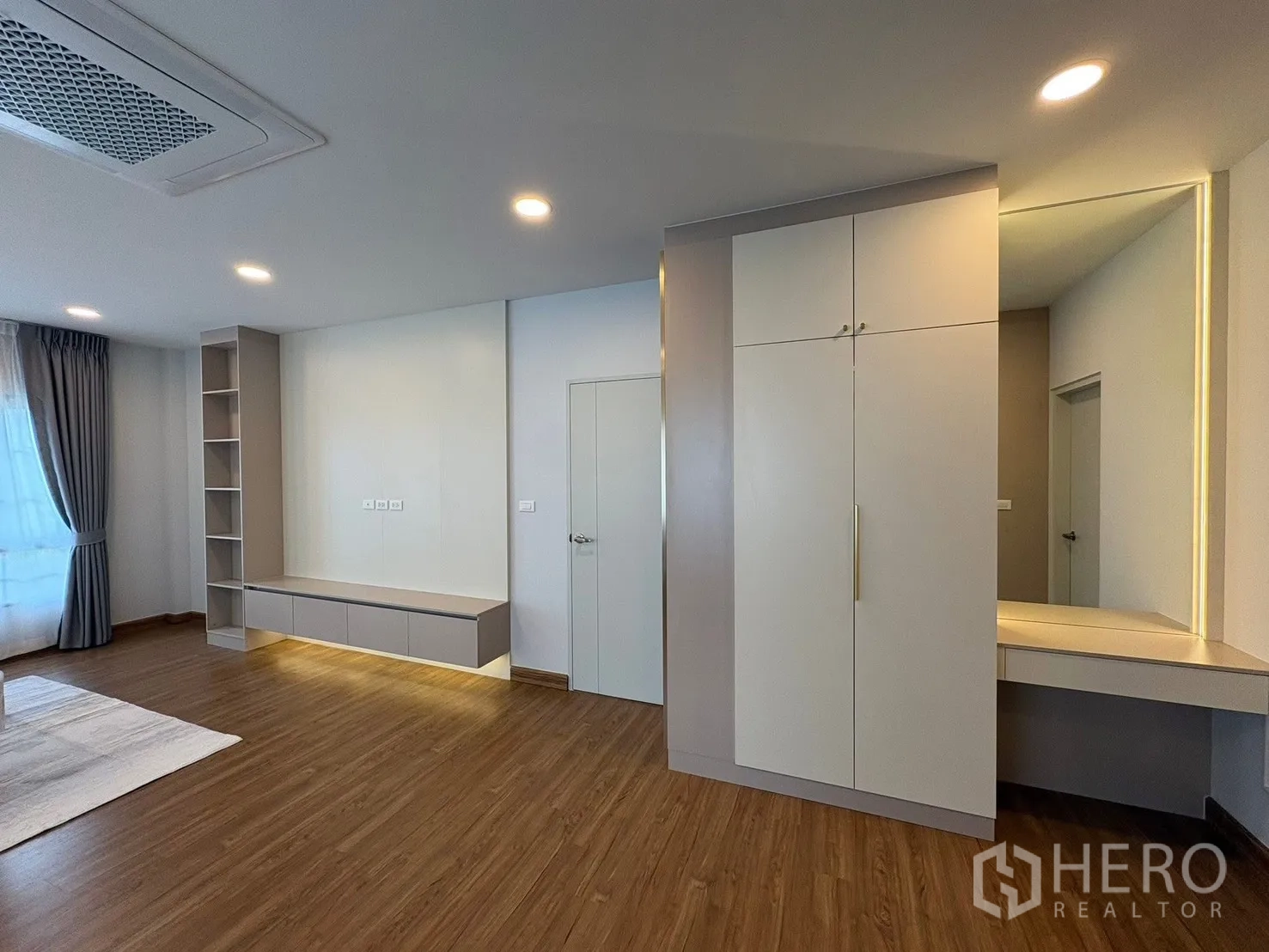 Detached House for rent in Bang Phli, Samut Prakan - Upstairs family room with built-in cabinet wall, open shelving, dressing nook and wood flooring.