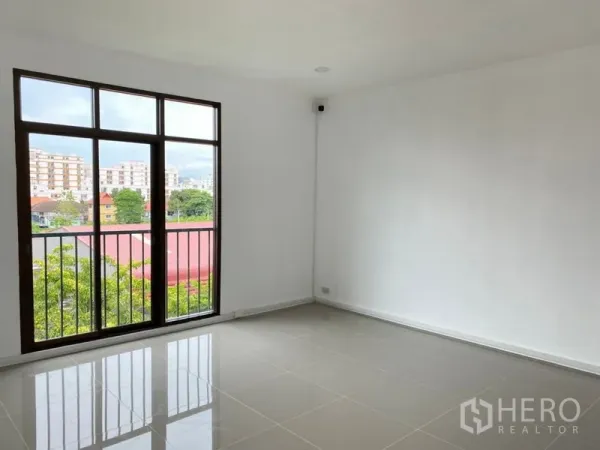 Home Office for rent in Wang Thonglang, Bangkok - Upper-floor room with tall window and city view over trees and rooftops.