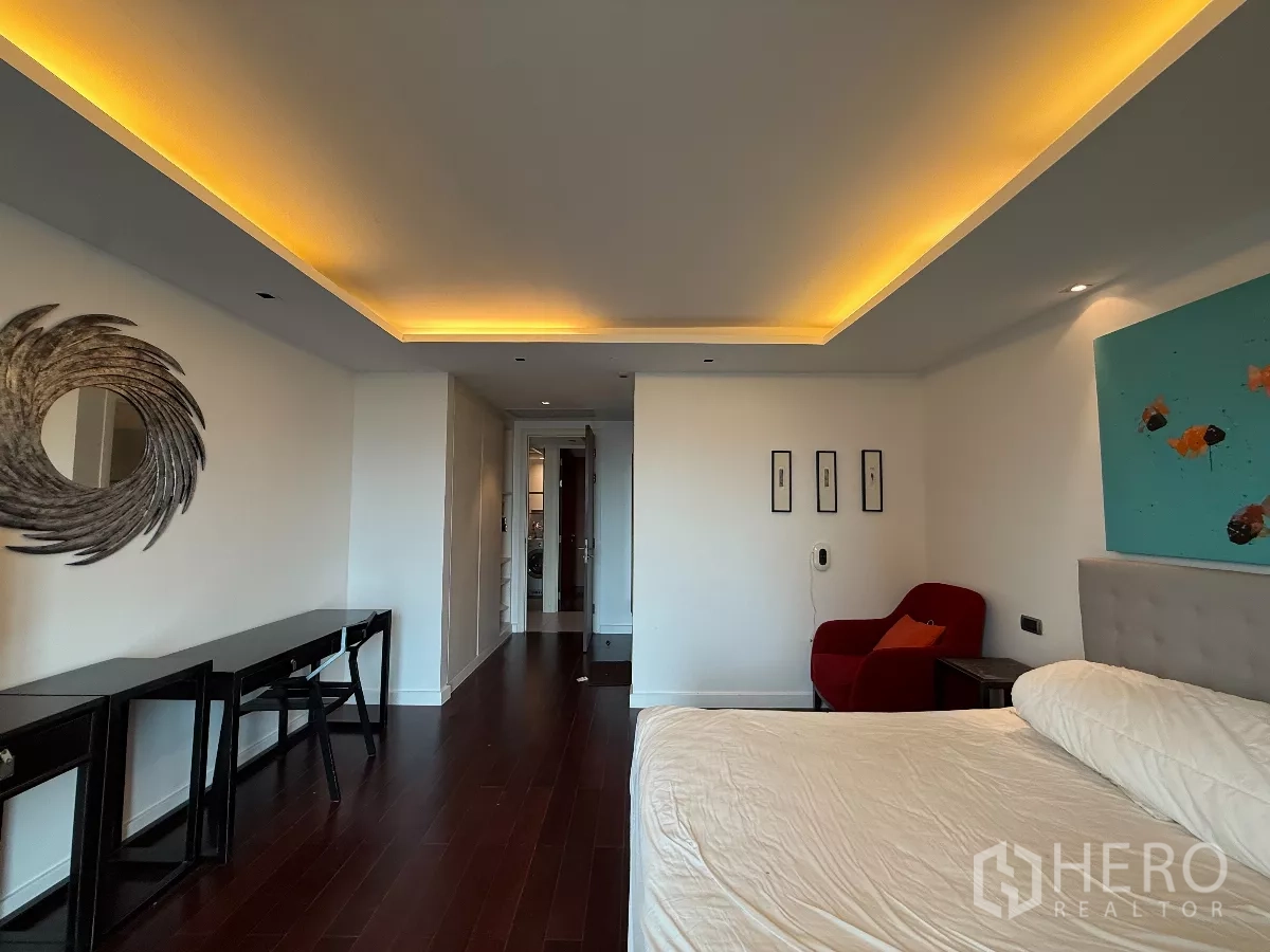 คอนโด ให้เช่าในPhaya Thai, Bangkok - ห้องนอนใหญ่เพดานไฟซ่อน พื้นไม้เข้ม เตียงและเก้าอี้พักผ่อน