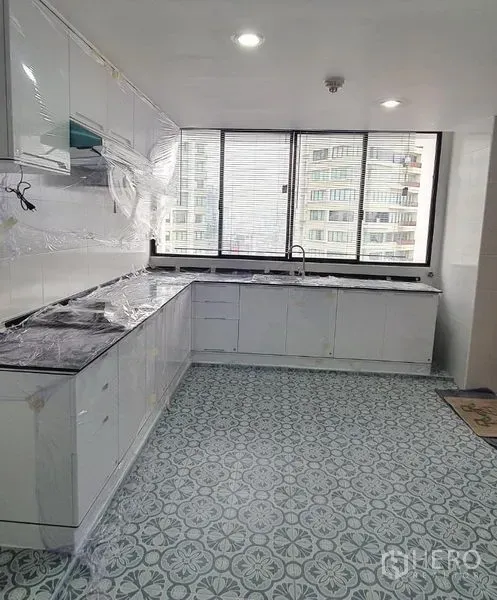 คอนโด ให้เช่าในKhlong Toei, Bangkok - ครัวแบบแกลลีย์สว่าง ตู้สีขาว พื้นกระเบื้องลาย และหน้าต่างบานกว้างวิวเมือง