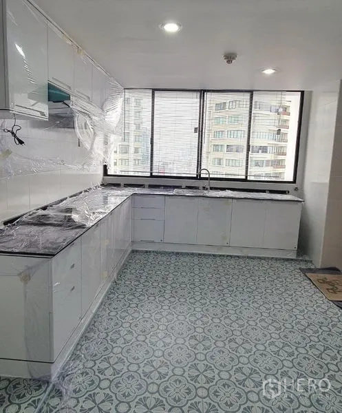 คอนโด ให้เช่าในKhlong Toei, Bangkok - ครัวแบบแกลลีย์สว่าง ตู้สีขาว พื้นกระเบื้องลาย และหน้าต่างบานกว้างวิวเมือง