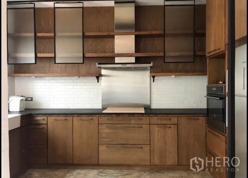 联排别墅 出售在Wang Thonglang, Bangkok - 现代厨房，木质橱柜、地铁砖墙面与不锈钢抽油烟机。
