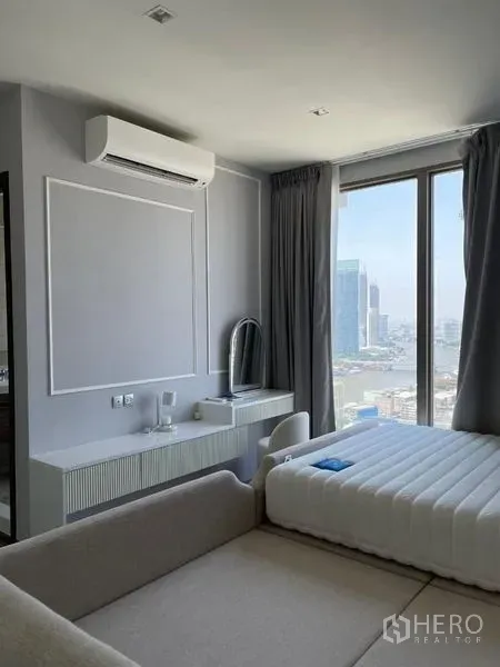 Condominium for rent in Bang Kho Laem, Bangkok - Bedroom with city views through a large window, desk, and built-in AC.