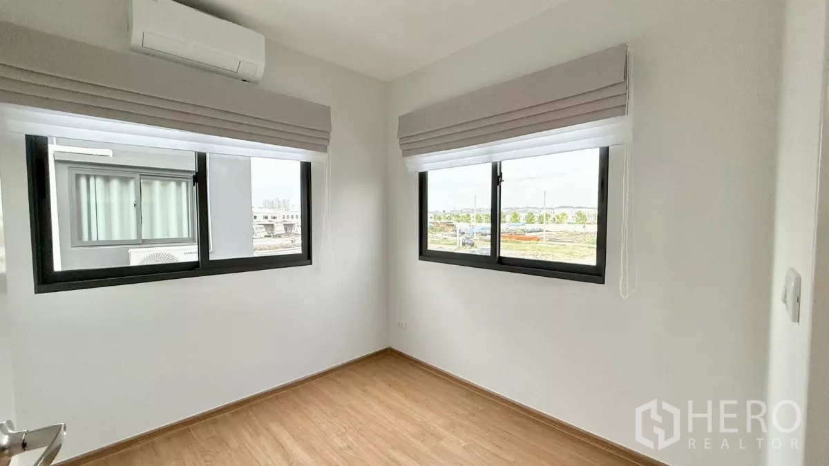 Townhouse for rent in Bang Phli, Samut Prakan - Bright third bedroom with twin corner windows and wood floor.