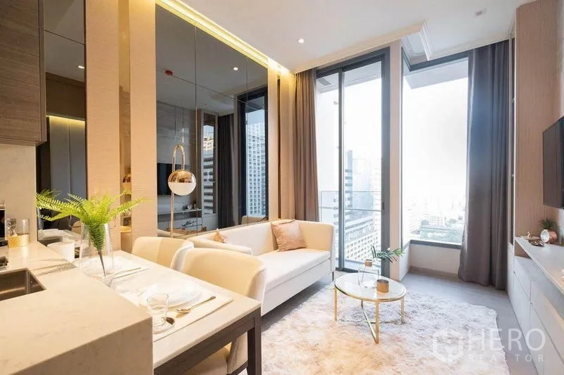 Condominium for rent in Watthana, Bangkok - Living room opening to balcony with city skyline view, plush rug and sleek sofa.