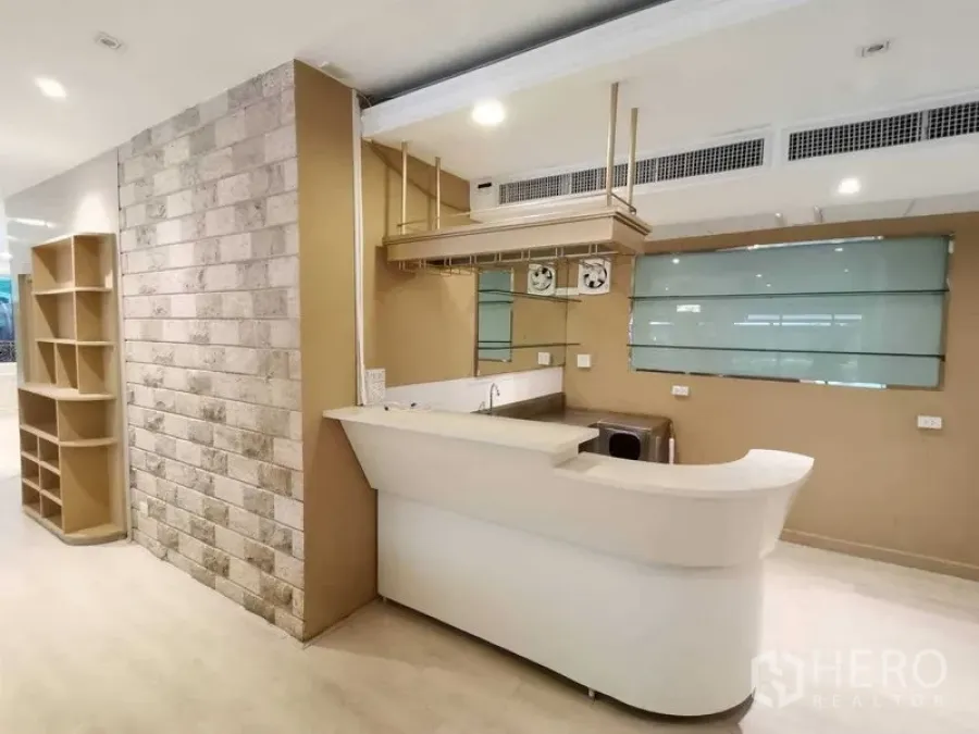 零售空间 出租在Pathum Wan, Bangkok - 零售空间一角，带前台吧台、水槽、吊架与仿石墙面。