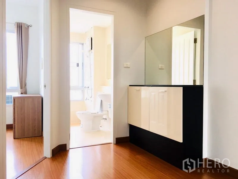 联排别墅 出租在Prawet, Bangkok - 二层过道带嵌入式柜与镜面，连接卧室与卫生间。