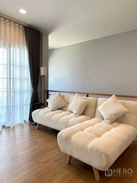 บ้าน ให้เช่าในBang Phli, Samut Prakan - โถงพักผ่อนชั้นบนพร้อมโซฟาสีครีมสองตัว ข้างหน้าต่างบานสูง