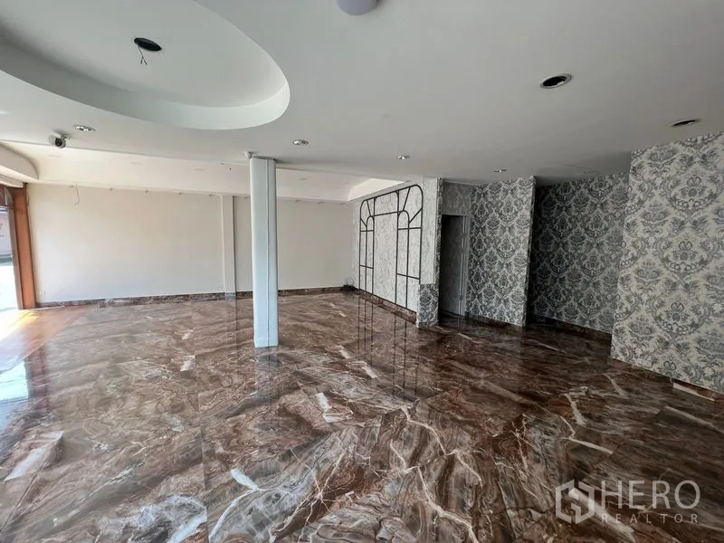 Retail Space for rent in Watthana, Bangkok - Main showroom with glossy marble floors, recessed lighting and central column.