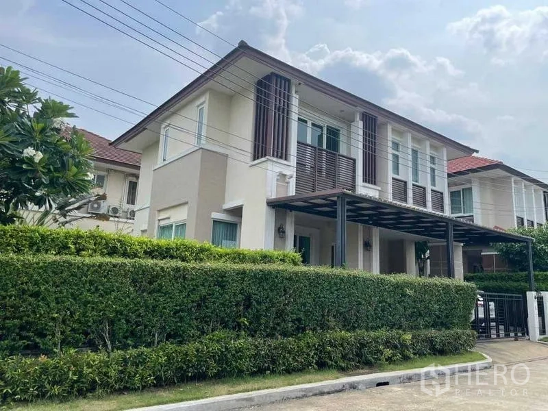 独立式住宅 出售在Bang Kruai, Nonthaburi - 当代外立面另一角度，可见绿篱与有顶停车位。
