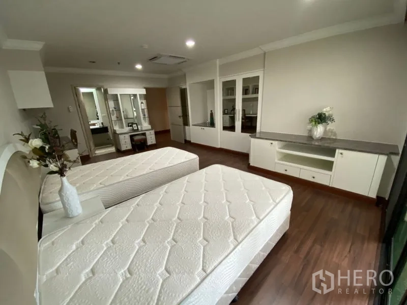 คอนโด ให้เช่าในWatthana, Bangkok - ห้องนอนเตียงคู่มุมมองอีกด้าน มีตู้เก็บของบิวต์อิน พื้นไม้ และทางเข้าห้องน้ำ