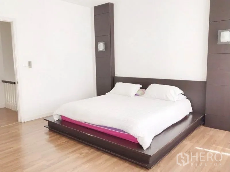 ทาวน์เฮาส์ ให้เช่าในPrawet, Bangkok - ห้องนอนใหญ่เตียงแพลตฟอร์ม ผ้าปูสีขาว และพื้นไม้โทนอุ่น