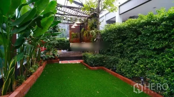 Detached House for rent or sale in Bang Phli, Samut Prakan - Lush private garden with artificial turf, brick edging, pergola and tall privacy hedges.
