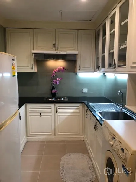 公寓 出租或出售在Sathon, Bangkok - U型厨房，橱柜齐全，水槽、灶台、冰箱与洗衣机。