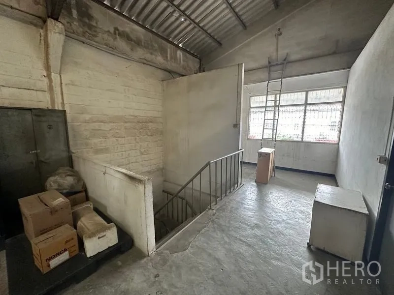 โรงงาน ให้เช่าในLam Luk Ka, Pathum Thani - ชานพักบันไดพื้นคอนกรีตภายในโรงงาน มีหน้าต่างและบันไดเหล็ก