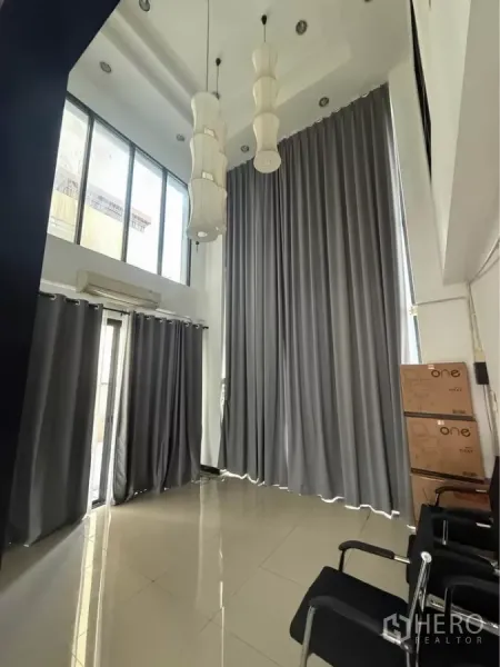 Home Office for rent in Wang Thonglang, Bangkok - Double-height lobby with tall curtains and pendant lights beside floor-to-ceiling windows.