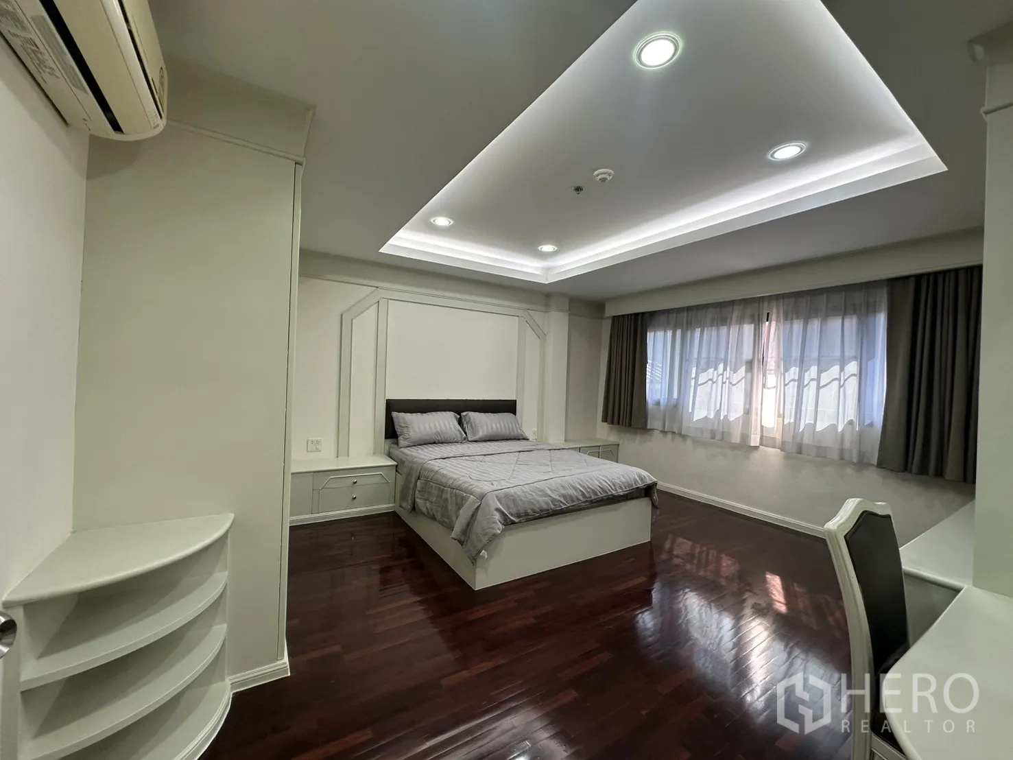 Condominium for rent in Watthana, Bangkok - Bedroom angle showing bed, window drapes, and work desk.