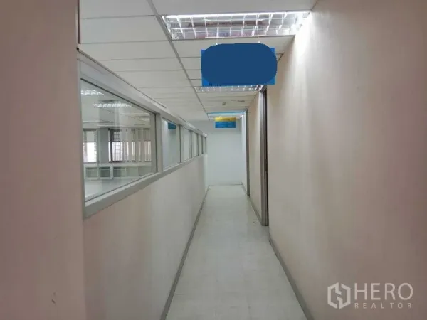 Office Space for rent in Watthana, Bangkok - Well-lit corridor with drop ceiling and interior windows leading to office rooms.