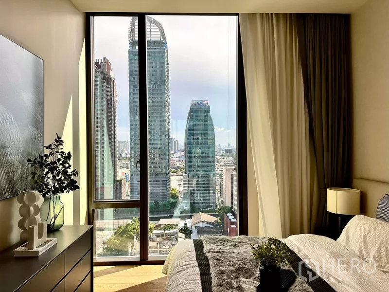 Condominium for rent in Pathum Wan, Bangkok - Master bedroom cityscape panorama from floor-to-ceiling window overlooking Bangkok towers.