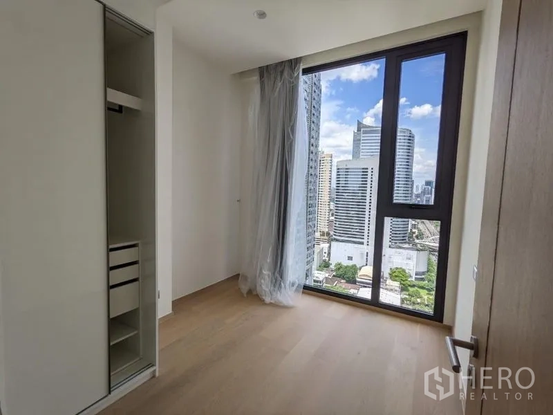 Condominium for sale - Secondary bedroom with a large window, built-in wardrobe, and skyline view.