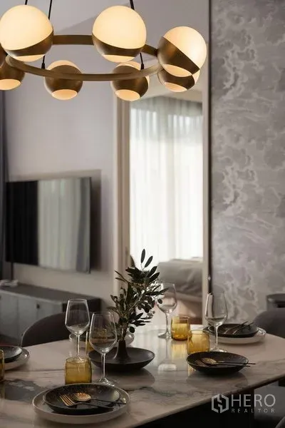 公寓 出租在Watthana, Bangkok - 通罗公寓内的金色球形吊灯与摆放整齐的石材餐桌特写。