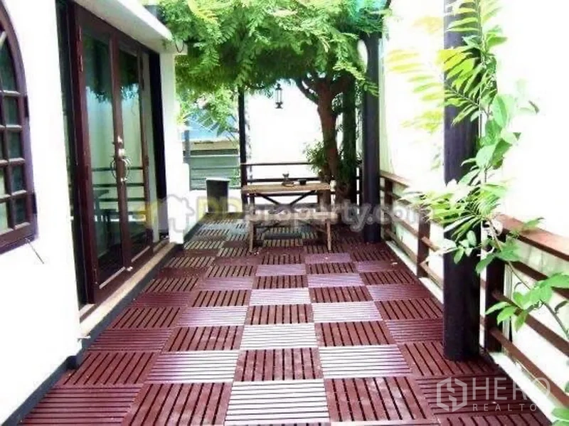 Detached House for rent in Wang Thonglang, Bangkok - Outdoor wood-deck terrace with bench seating under greenery and sliding doors.