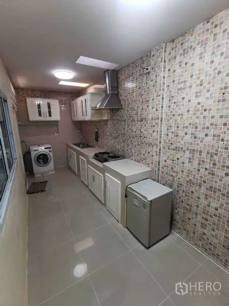 ทาวน์เฮาส์ ให้เช่าในChatuchak, Bangkok - ครัวแบบแกลลี่ผนังโมเสก เตาแก๊ส เครื่องดูดควัน ตู้เก็บของ และเครื่องซักผ้า.