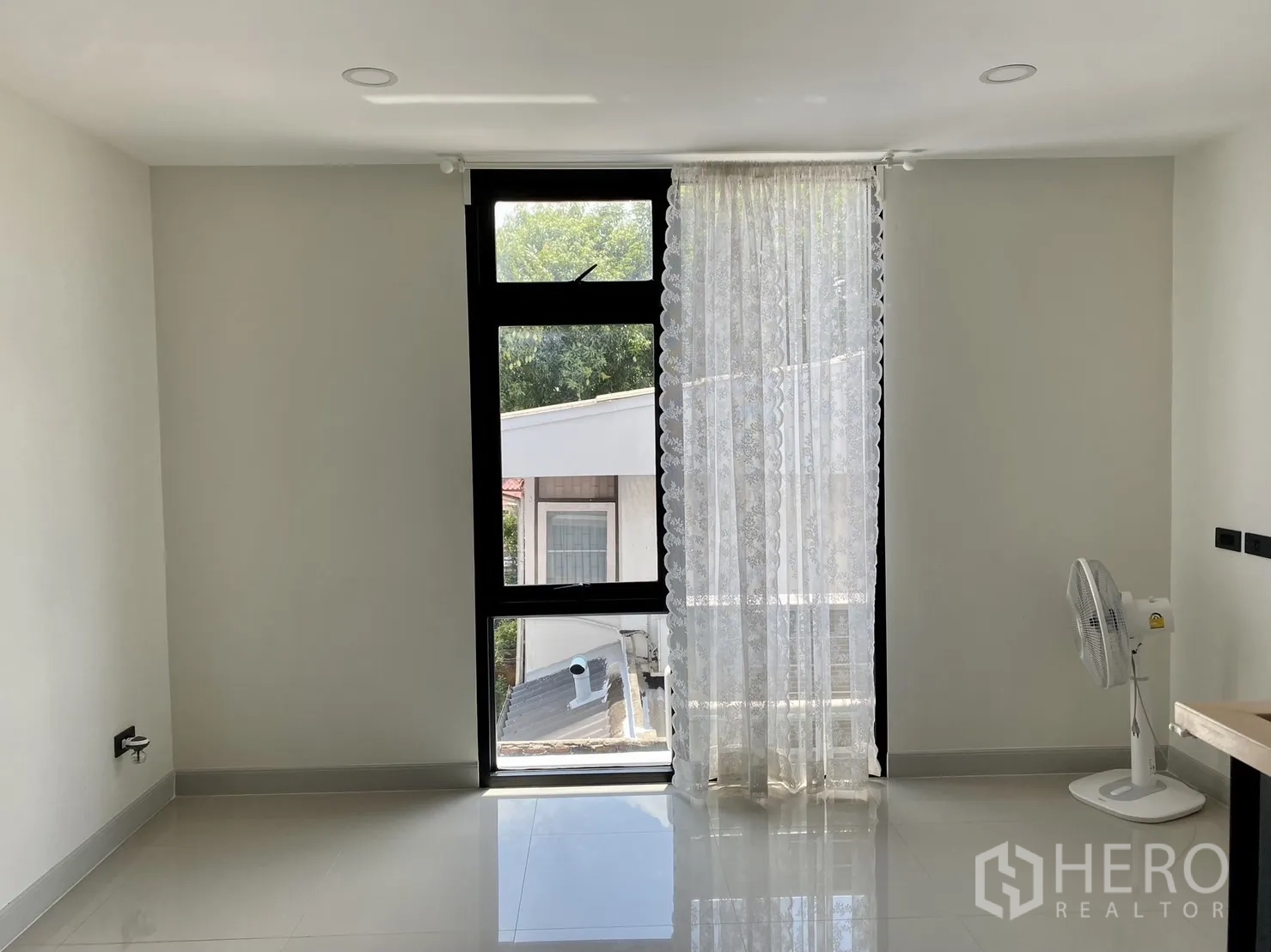 Home Office for rent or sale in Phra Khanong, Bangkok - Bright room with tall window, sheer curtain and portable fan.