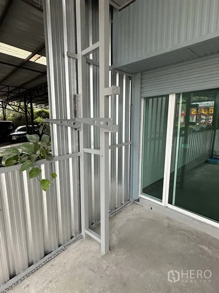 คลังสินค้า ให้เช่าในLat Krabang, Bangkok - มุมใกล้ของผนังภายนอกพร้อมประตูกระจกเข้าสำนักงานข้างประตูม้วน