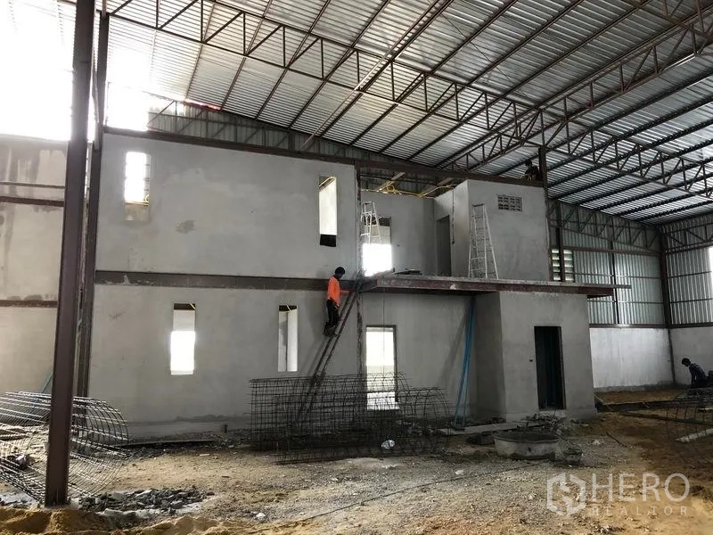 Warehouse for rent or sale in Sai Noi, Nonthaburi - Alternate view of the mezzanine and office core beneath the high metal roof.