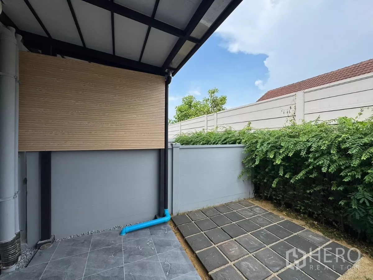 ทาวน์เฮาส์ ให้เช่าในBang Phli, Samut Prakan - ลานหลังบ้านปูกระเบื้อง กำแพงสูง พร้อมแนวไม้พุ่ม