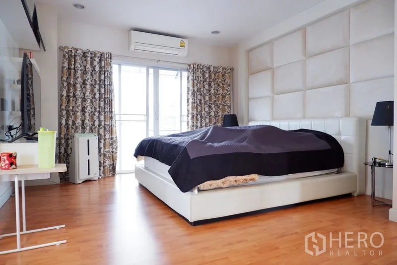 บ้าน ขายในSaphan Sung, Bangkok - ห้องนอนใหญ่ ผนังหัวเตียงบุ และประตูกระจกออกสู่ระเบียง