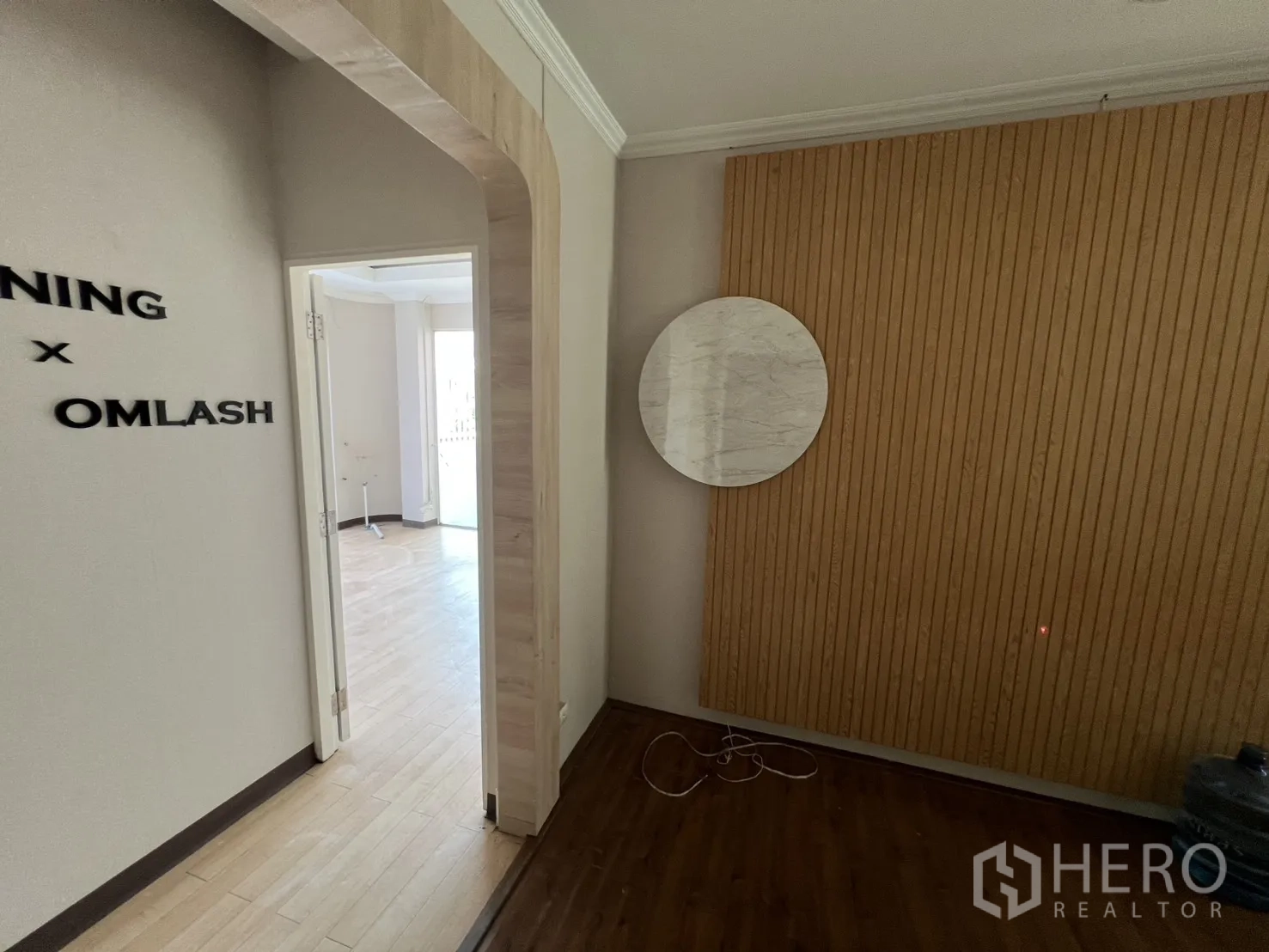 พื้นที่ขายปลีก ให้เช่า - ช่องโค้งกับผนังซี่ไม้และกระจกกลม มองไปยังห้องสว่าง