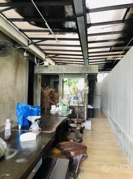 อาคารพาณิชย์ ให้เช่าในChatuchak, Bangkok - เฉลียงด้านข้างหลังคาเหล็ก โต๊ะไม้ยาวและม้านั่ง