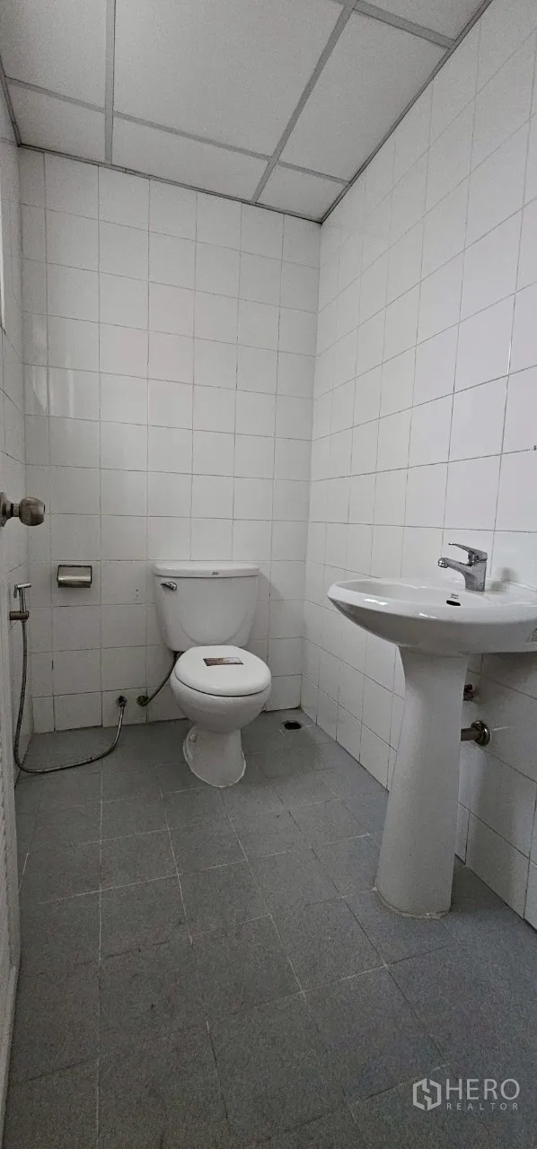 Office Space for rent in Bueng Kum, Bangkok - Clean tiled restroom with toilet, sink and hand spray.