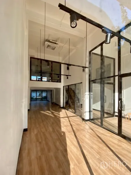 Home Office for rent in Phra Khanong, Bangkok - Loft-style double-height lobby with floor-to-ceiling glass, wood flooring and a mezzanine.