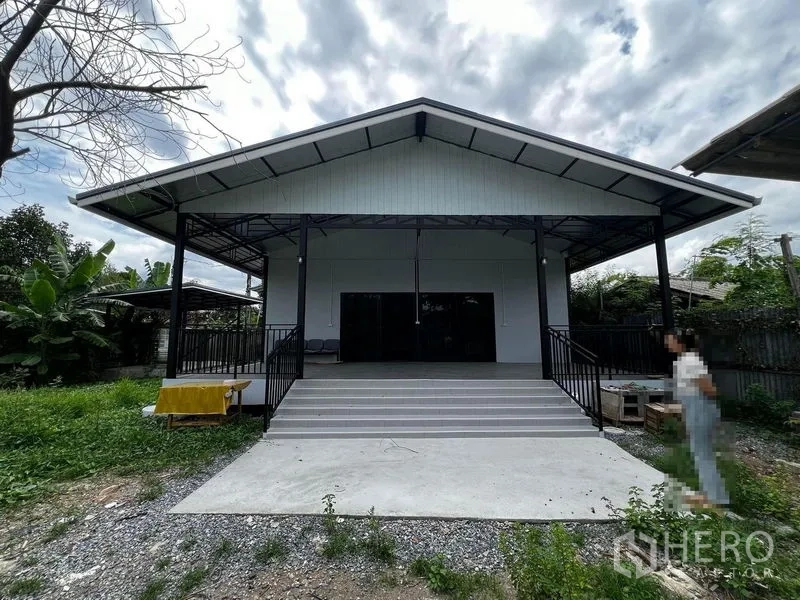 Warehouse for rent in Suan Luang, Bangkok - Front view of single-storey warehouse with wide steps, metal roof and covered loading deck.