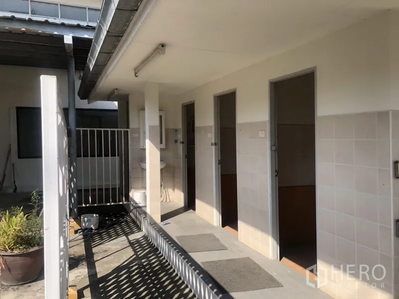 Warehouse for rent in Prawet, Bangkok - Tiled restroom area with separate stalls and outdoor wash basin beside the warehouse.