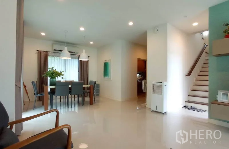 Detached House for rent in Bang Kapi, Bangkok - Open-plan dining area with pendant lights next to the staircase and large windows.