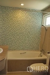 Condominium for rent in Pathum Wan, Bangkok - Bathroom with bathtub, mosaic feature wall, shower and vanity.