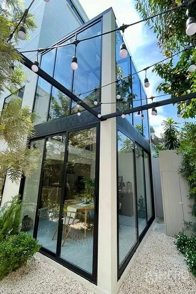 ทาวน์เฮาส์ ขายในKhlong Toei, Bangkok - มุมอาคารกระจกเต็มผนังสมัยใหม่พร้อมไฟประดับในสวนของทาวน์เฮ้าส์