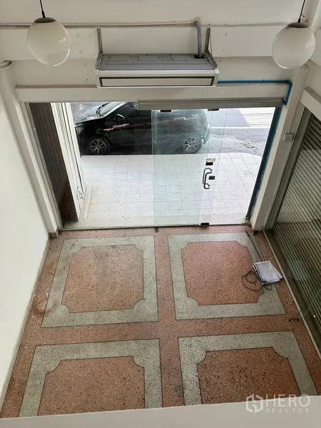 อาคารพาณิชย์ ให้เช่าในBangkok - พื้นที่ค้าขายชั้นล่าง พื้นหินขัด และประตูกระจก มองจากชั้นลอย.