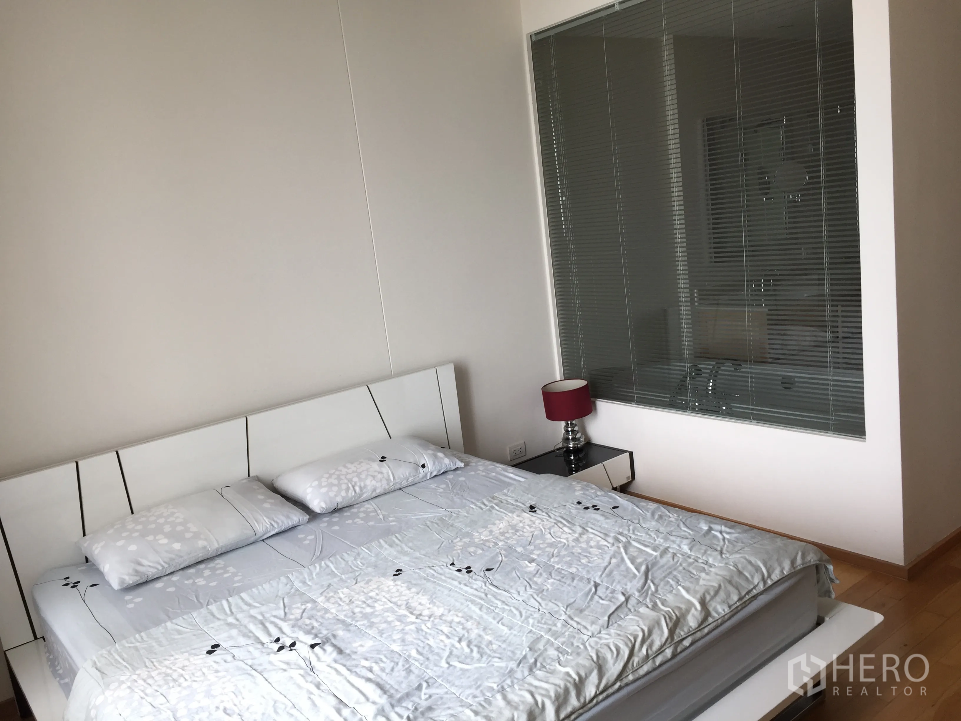 Condominium for rent in Sathon, Bangkok - Master bedroom with king bed and a feature glass wall looking into the ensuite bathroom with bathtub.