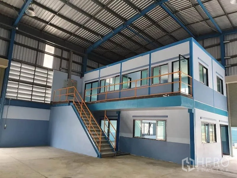 工厂 出租或出售在Phanat Nikhom, Chon Buri - 厂房内的两层办公室模块及楼梯，俯瞰生产区域。