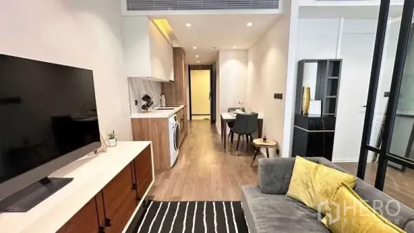 คอนโด ให้เช่าในWatthana, Bangkok - โซนห้องนั่งเล่นเชื่อมครัวขนาดกะทัดรัด มีเครื่องซักผ้า โต๊ะทานข้าว และพื้นไม้