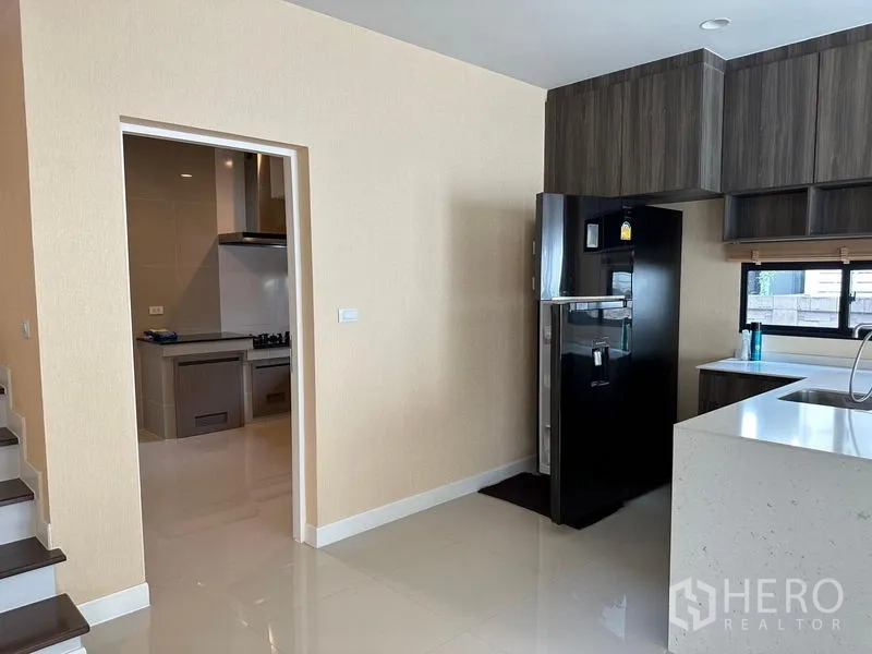 บ้าน ให้เช่าหรือขายในLam Luk Ka, Pathum Thani - แพนทรี่พร้อมไอส์แลนด์และตู้ลอย ติดประตูทางเข้าครัวไทยและบันได