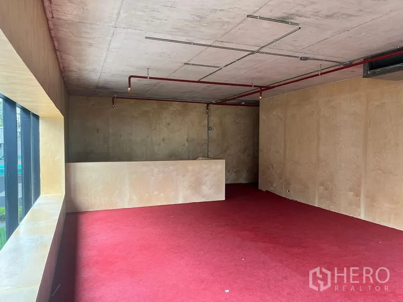 พื้นที่ขายปลีก ให้เช่าในWatthana, Bangkok - โซนเปิดโล่งปูพรมแดง มีผนังกั้นเตี้ย และช่องแสงยาวตลอดแนว